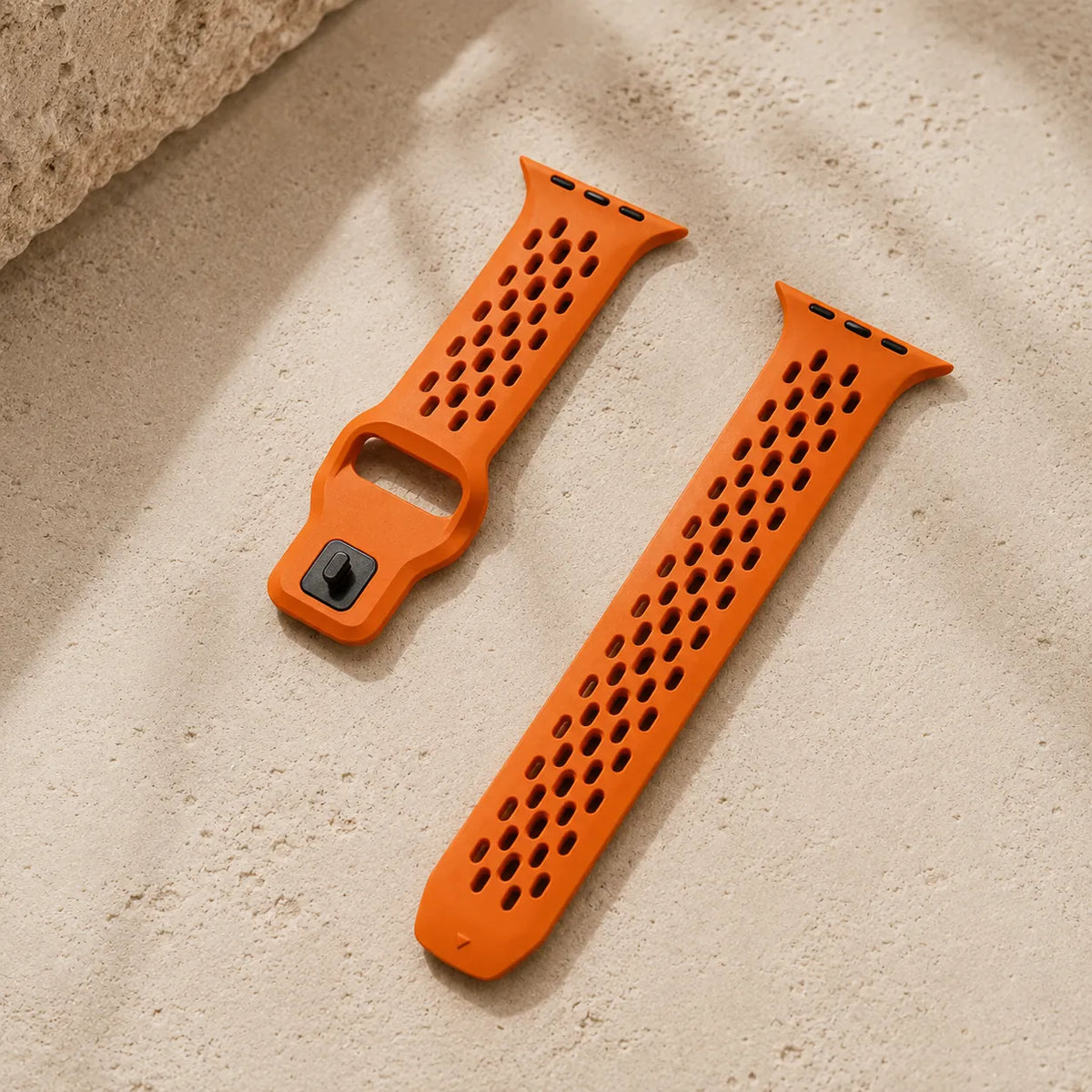 Ventilation openings and pin-and-tuck closure on an orange FKM Apple Watch band
