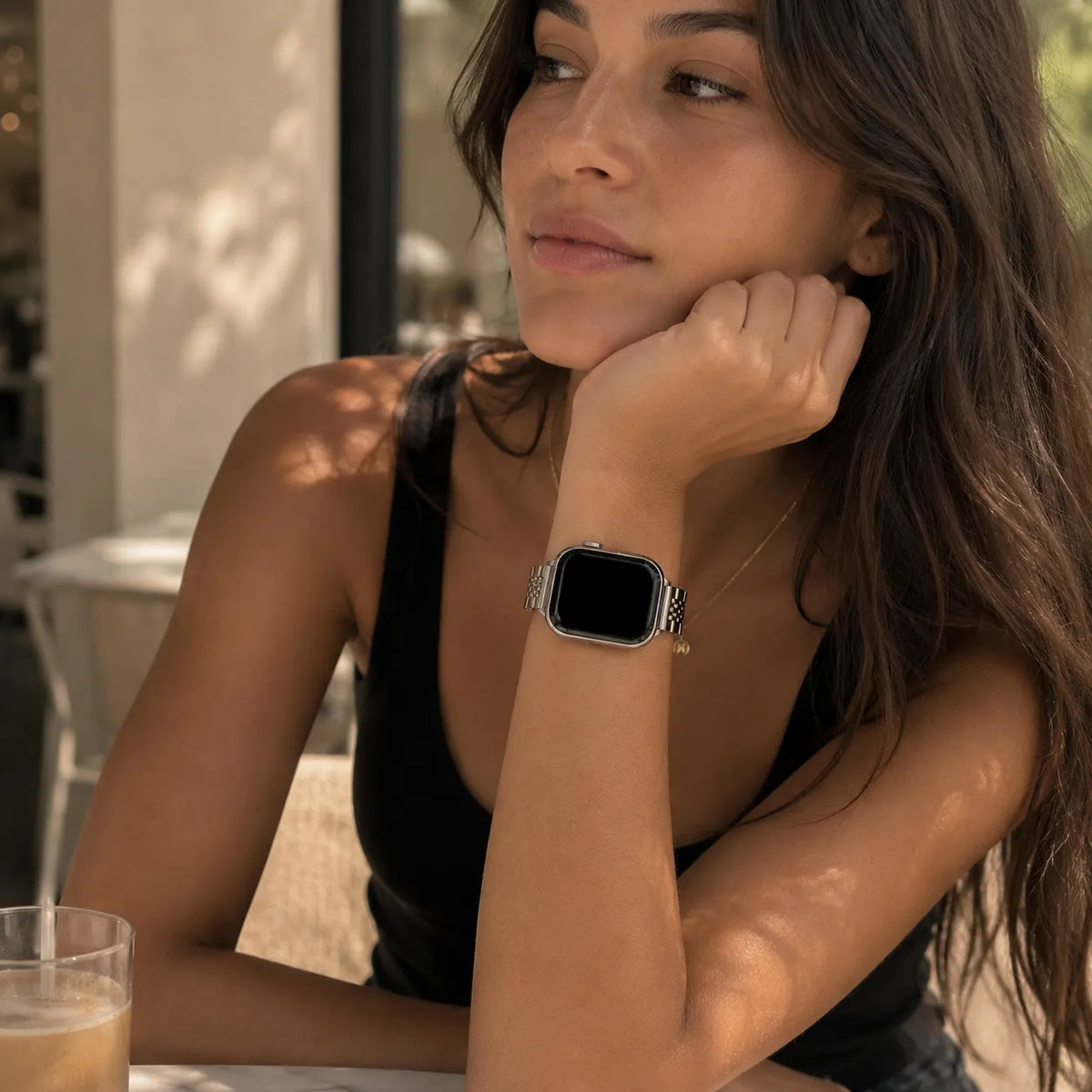 Donna con elegante bracciale Apple Watch argentato e outfit nero