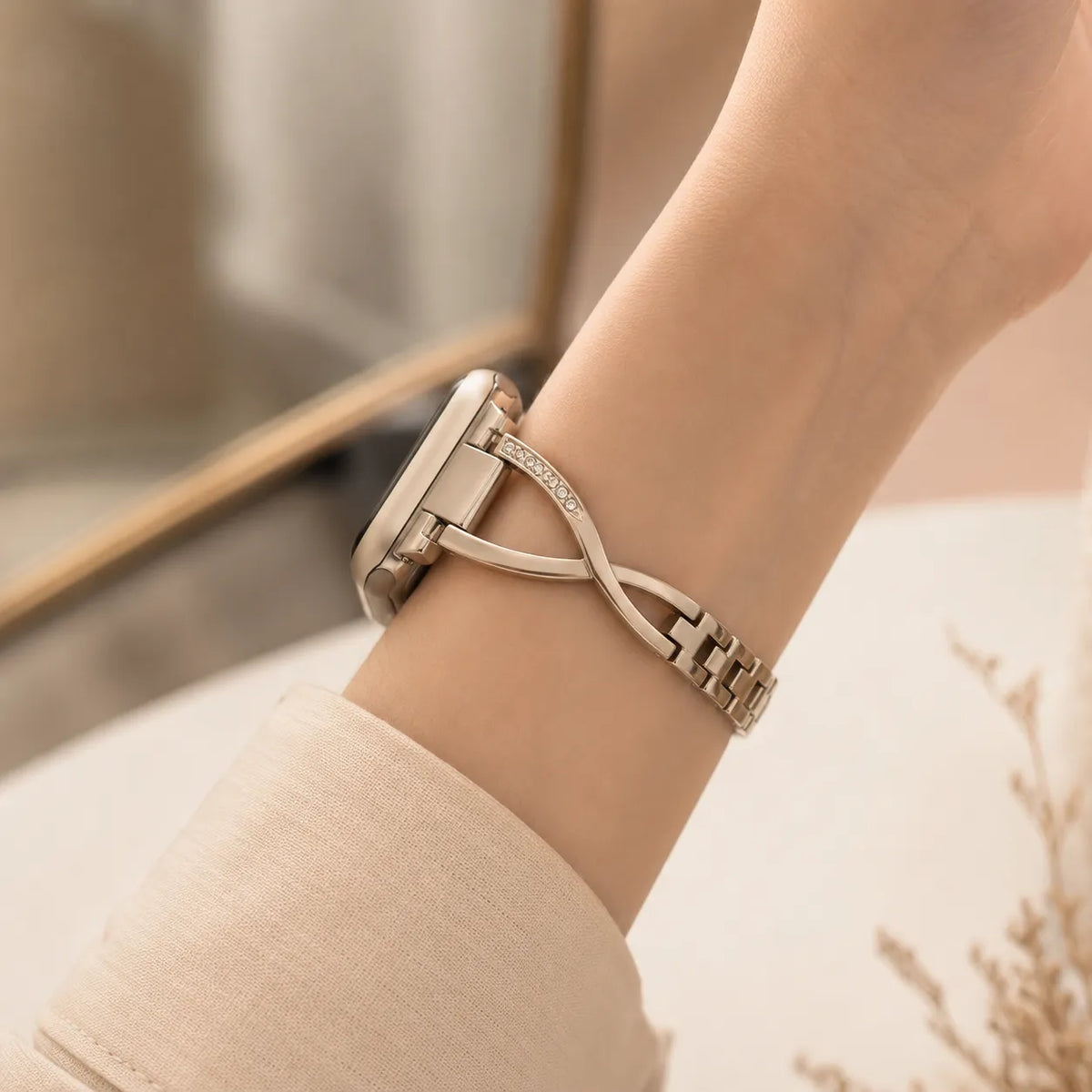 Schmales silberfarbenes Apple Watch-Armband mit offenem Crossover-Design am Handgelenk