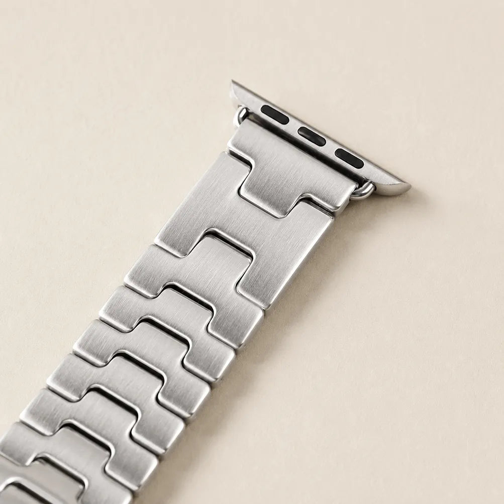 Close view of the interlocking H-shaped links and brushed steel surface