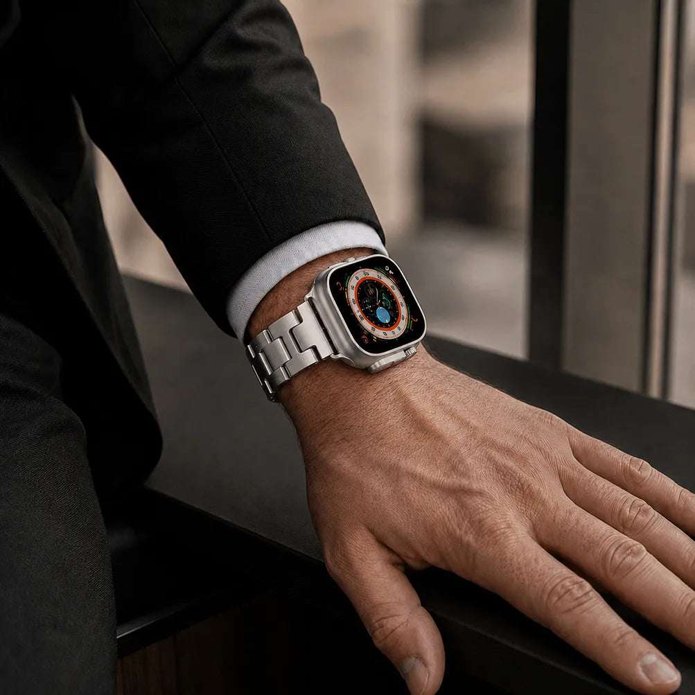 Silver H-shaped stainless steel Apple Watch band worn with a dark suit
