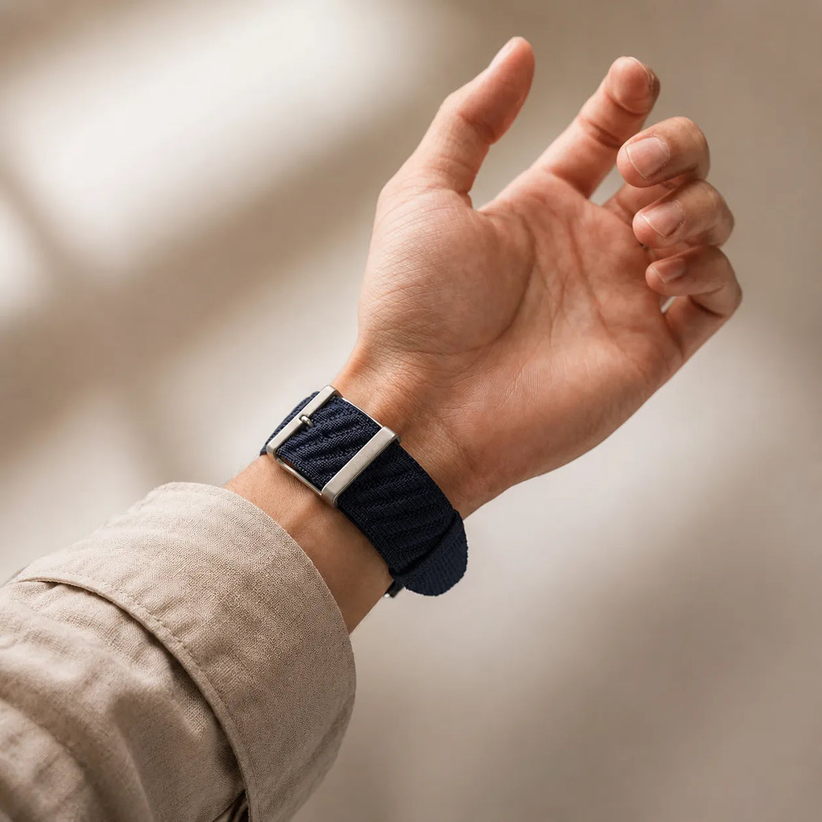 Blue twill knit nylon Apple Watch band worn on the wrist