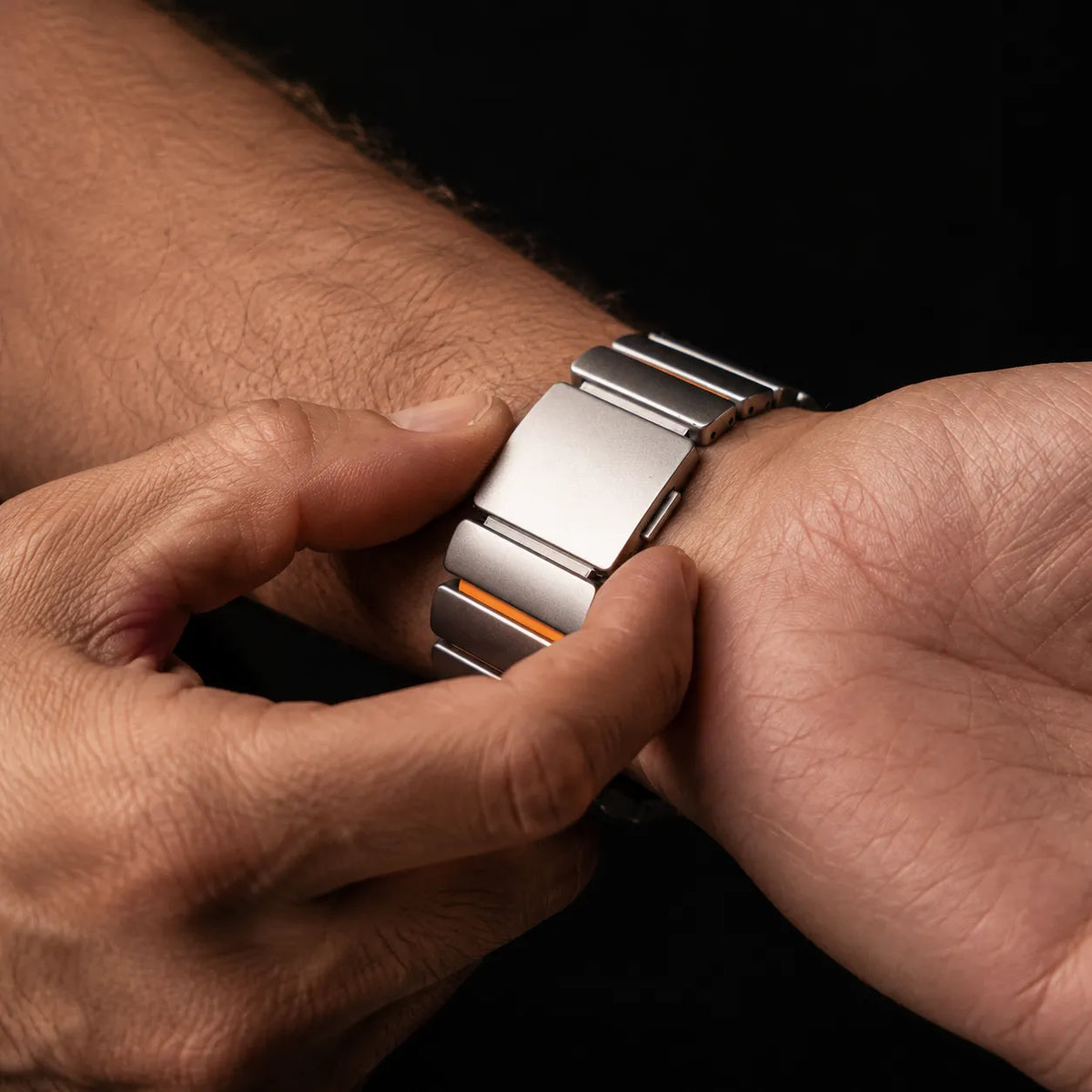 Magnetic folding clasp being closed on a metal and silicone Apple Watch band