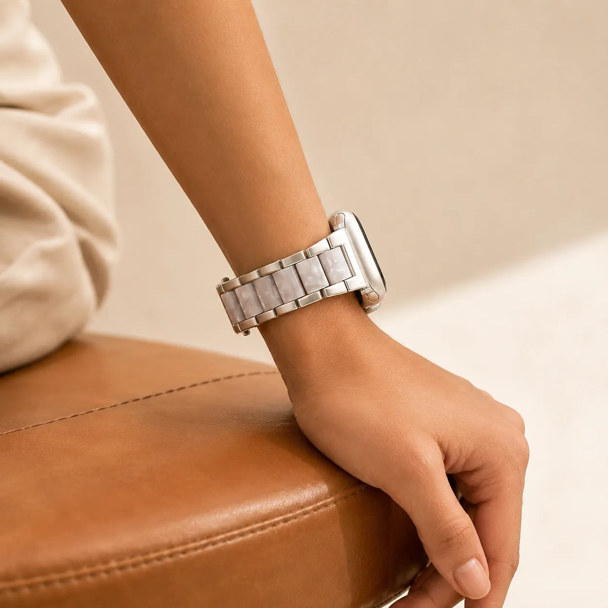 브레이슬릿 스타일의 핏을 보여주는 실버 및 화이트 레진 메탈 Apple Watch 밴드