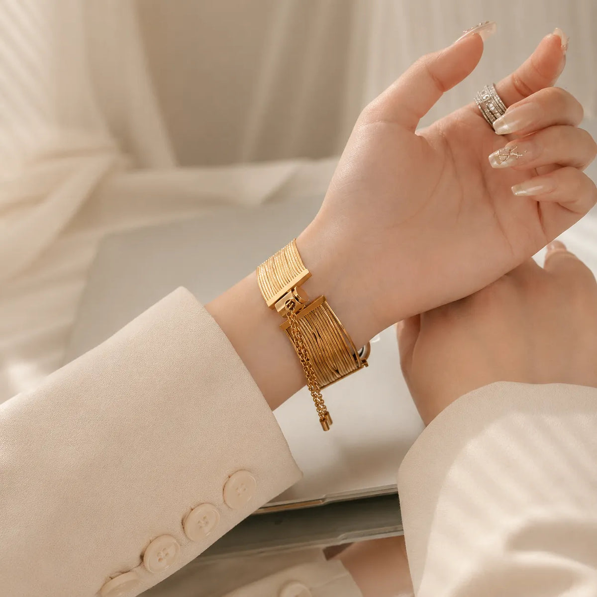 Goldfarbenes Apple Watch-Armband mit Quastenketten, Zugverschluss und herabhängenden Kettenenden