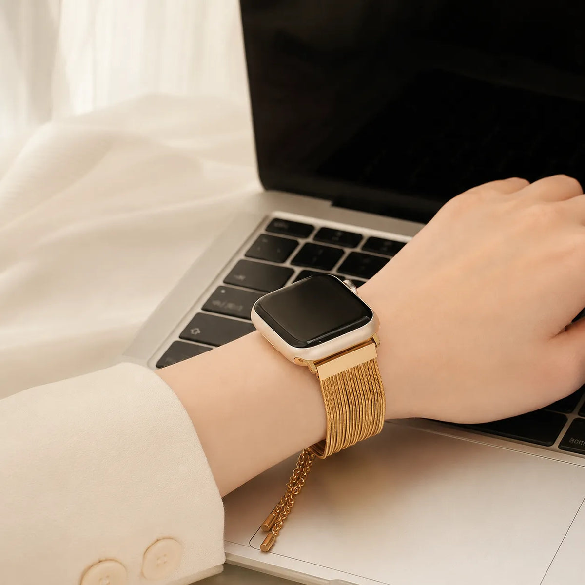 Goldfarbenes Edelstahlarmband mit Quastenketten für die Apple Watch am Handgelenk