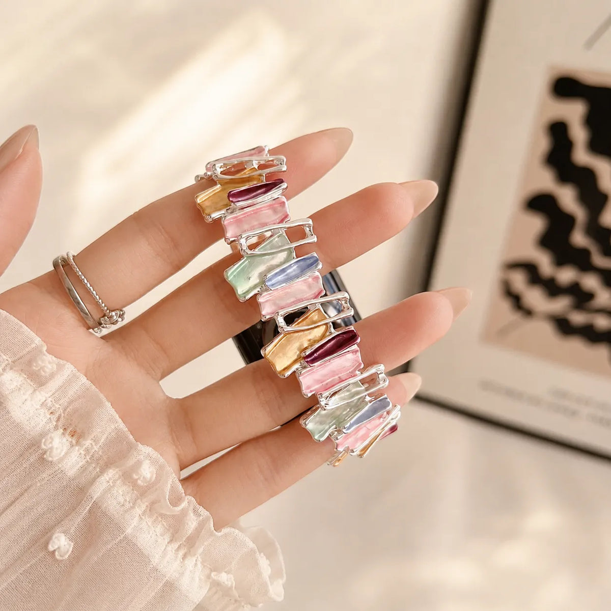 Irregular pastel links and polished frames on a metal scrunchie Apple Watch band
