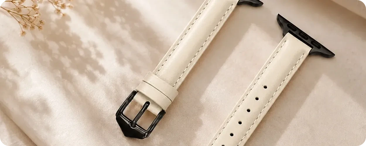 White leather Apple Watch band with buckle, connectors, and adjustment holes