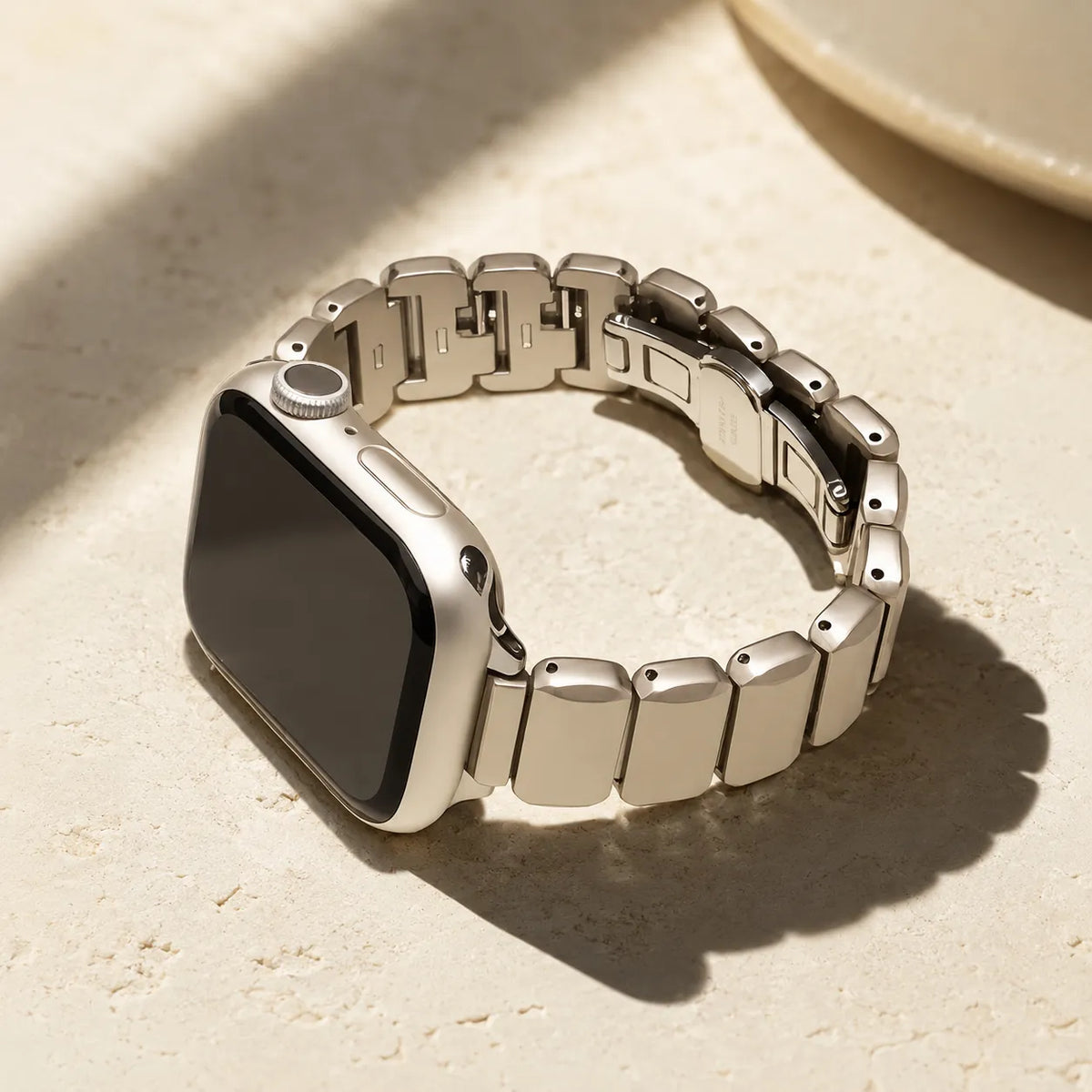 Polished cube-shaped links on a starlight stainless steel Apple Watch bracelet